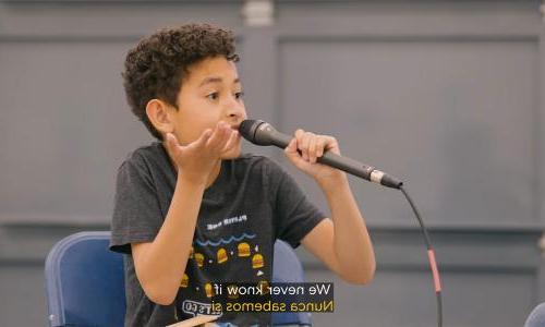 A still from the video Sea level rise, explained by kids showing a kid holding a microphone.